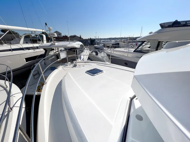 Slide: The Image of 2023 Beneteau Swift Trawler 35 on display at marina, surrounded by other boats. - 17