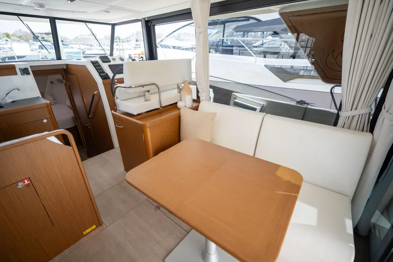 Slide: The Image of Interior of 2023 Beneteau Swift Trawler 35, featuring a cozy dining area with wooden table. - 2