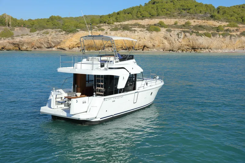 Slide: The Image of 2023 Beneteau Swift Trawler 35 cruising near rocky coastline. - 22