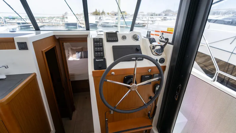Slide: The Image of 2023 Beneteau Swift Trawler 35 helm with modern controls and panoramic view. - 8