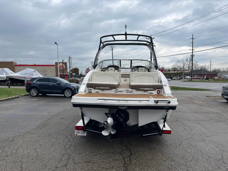 Slide: The Image of 2014 Chaparral 257 SSX boat, rear view, parked in a lot under cloudy skies. - 15