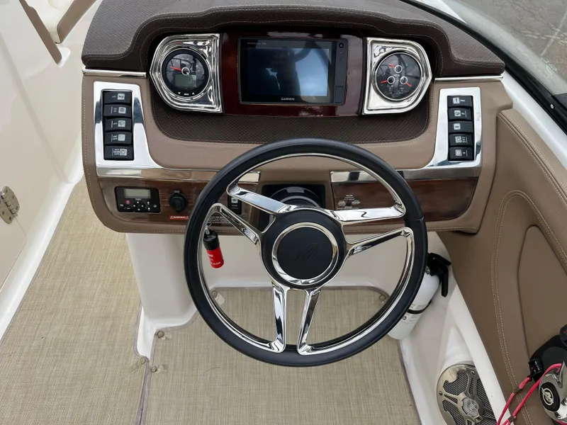 Slide: The Image of 2014 Chaparral 257 SSX boat dashboard with steering wheel and control panel. - 8