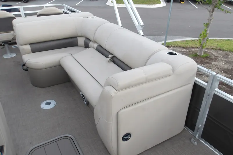 Slide: The Image of 2025 Sun Tracker Fishin' Barge 22 XP3 interior with beige seating and cup holders. - 17