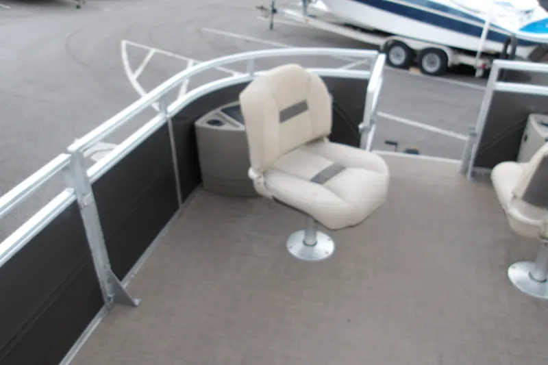 Slide: The Image of 2025 Sun Tracker Fishin' Barge 22 XP3 boat interior with seating and railing. - 14