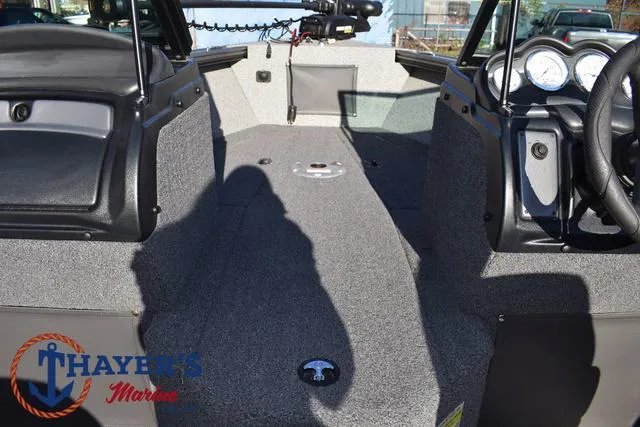 Slide: The Image of 2023 Lund 1875 Fisherman Sport boat interior with gray carpet and dashboard controls. - 11