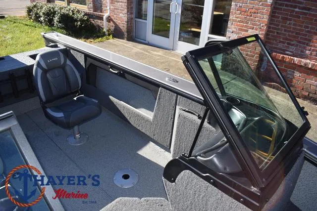 Slide: The Image of 2023 Lund 1875 Fisherman Sport boat interior with seating and windshield, displayed at Thayer's Marine. - 16