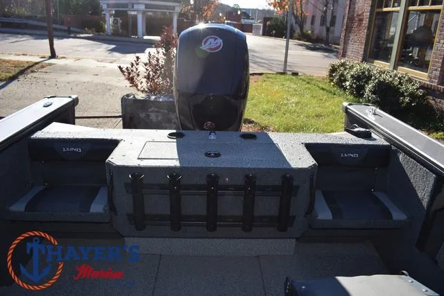 Slide: The Image of 2023 Lund 1875 Fisherman Sport boat interior with motor, docked outdoors. - 20