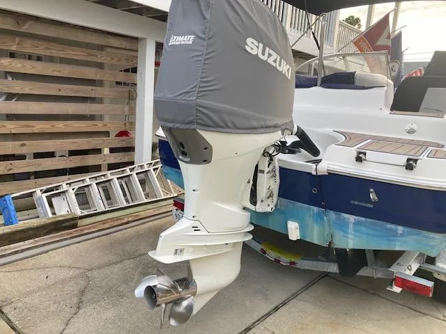 Slide: The Image of 2006 Hurricane SunDeck 237 OB with Suzuki outboard motor, parked on a trailer. - 5