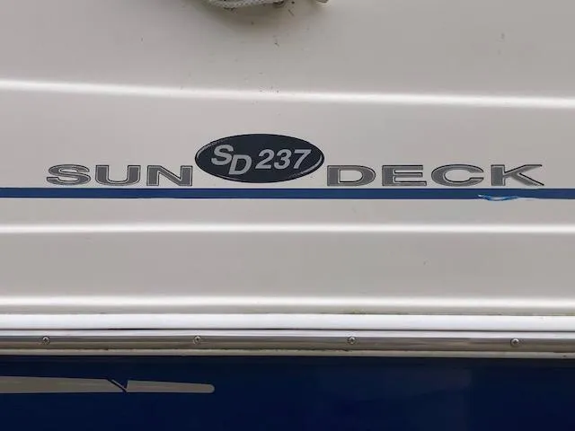 Slide: The Image of 2006 Hurricane SunDeck 237 OB boat logo on white surface. - 7