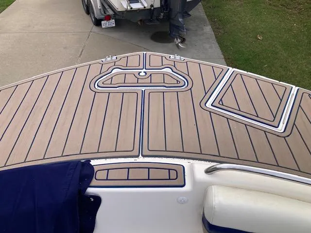 Slide: The Image of 2006 Hurricane SunDeck 237 OB boat deck with wood finish and blue accents. - 8