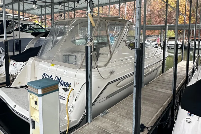 The Image of 1998 Maxum 3700 SCR yacht docked in a marina under a covered slip. - 0