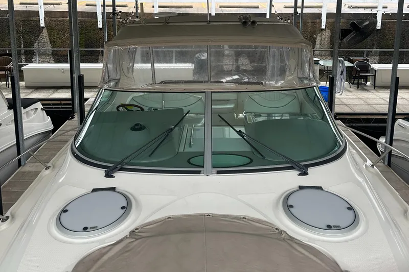 Slide: The Image of 1998 Maxum 3700 SCR boat docked, featuring a sleek windshield and dual hatches. - 18