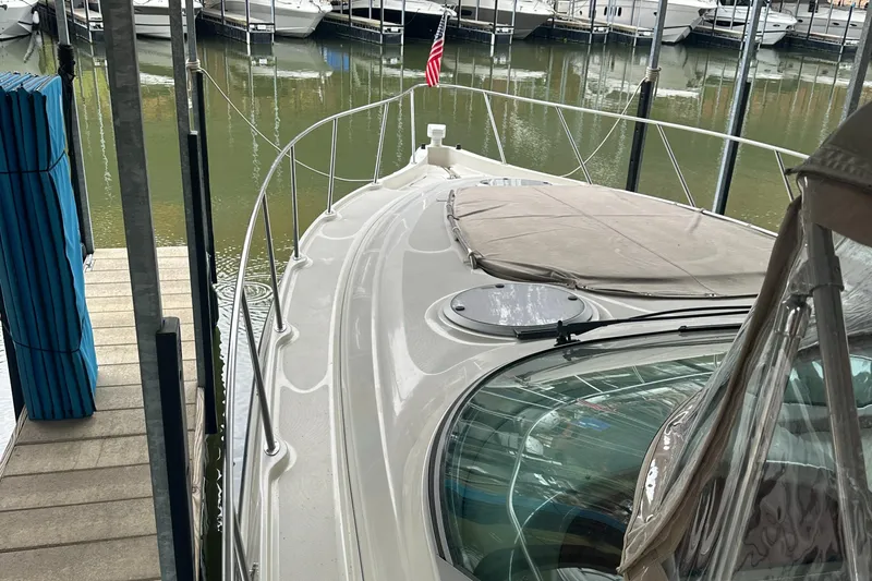 Slide: The Image of 1998 Maxum 3700 SCR yacht docked in marina, featuring sleek design and American flag. - 19