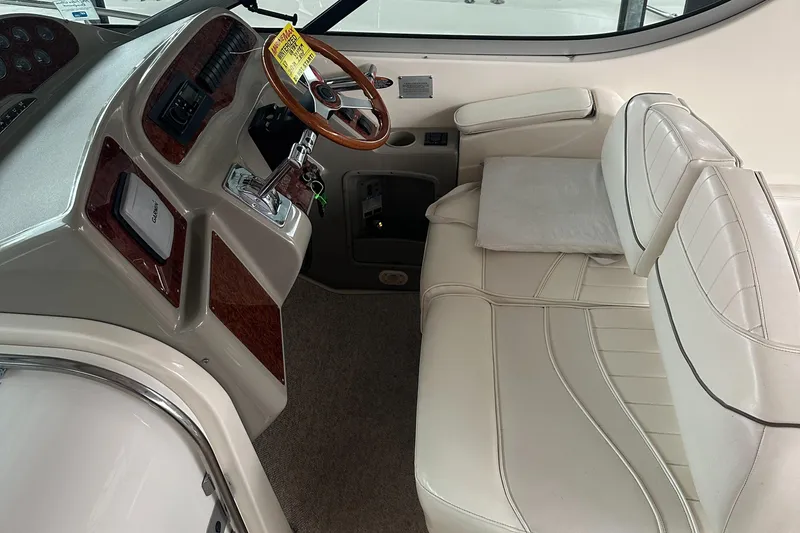 Slide: The Image of 1998 Maxum 3700 SCR boat interior with white leather seating and wooden steering wheel. - 23