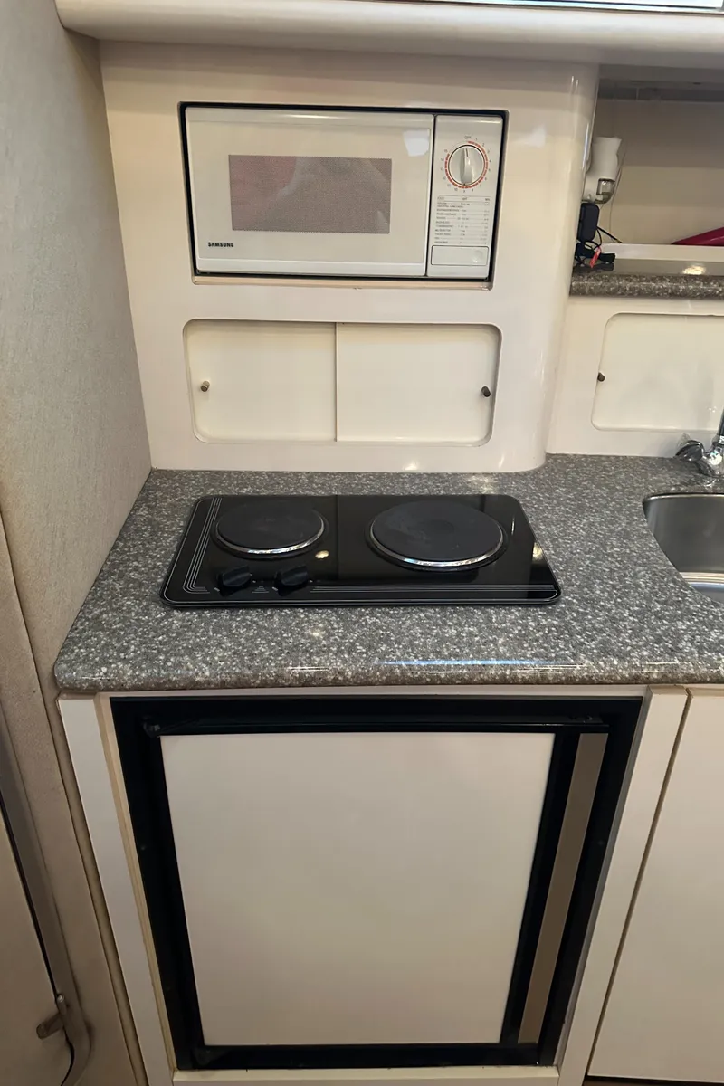 Slide: The Image of 1998 Maxum 3700 SCR yacht kitchen with microwave, stovetop, and sink. - 37