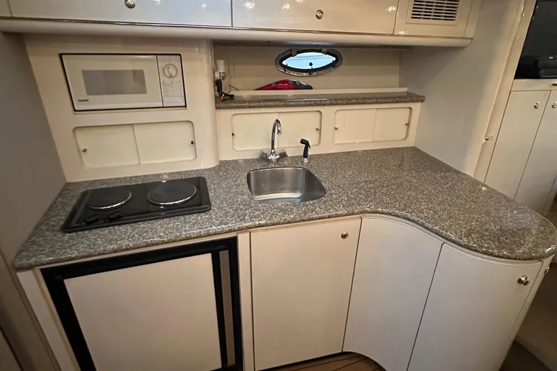 Slide: The Image of 1998 Maxum 3700 SCR yacht kitchen with stove, sink, and microwave. - 5