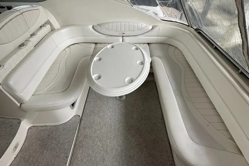 Slide: The Image of 1998 Maxum 3700 SCR boat interior with white seating and round table. - 7