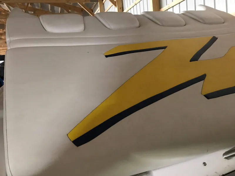 Slide: The Image of 2007 Donzi 28 ZX Open boat seat with yellow and black design in a garage. - 18