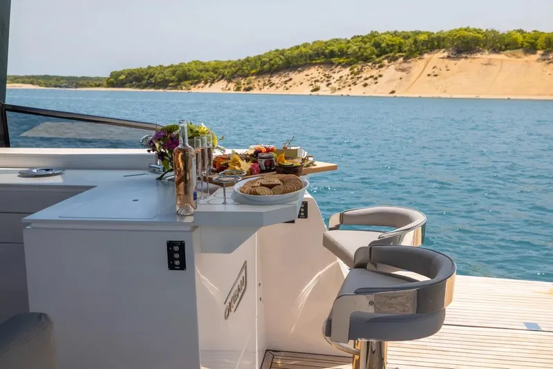 Slide: The Image of Luxury OKEAN 57 yacht with elegant dining setup overlooking serene waters, 2023 model. - 13