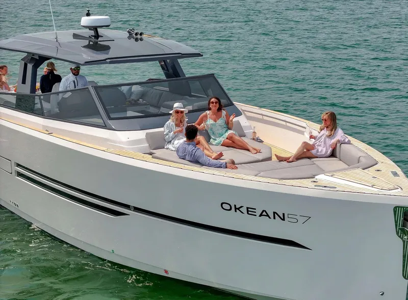 Slide: The Image of Luxury 2023 OKEAN 57 yacht with people relaxing on deck in open water. - 6