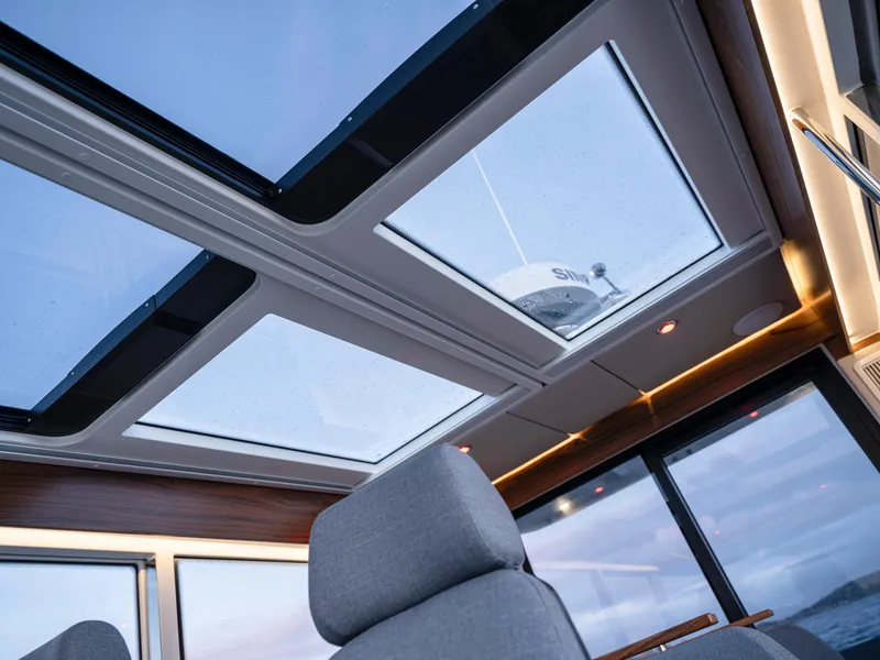 Slide: The Image of Interior view of 2025 Nimbus C11 boat with panoramic glass roof and modern seating. - 23