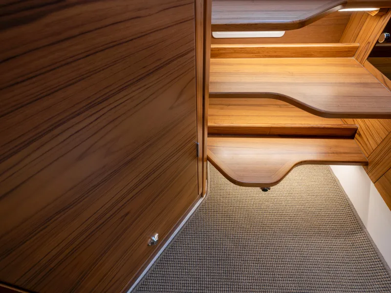 Slide: The Image of Wooden interior stairs in 2025 Nimbus C11 boat, featuring sleek design and carpeted flooring. - 27