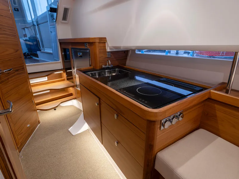 Slide: The Image of Luxurious 2025 Nimbus C11 yacht interior with modern kitchen and wooden cabinetry. - 28