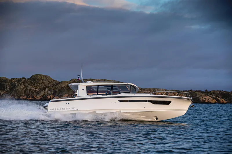 Slide: The Image of Nimbus C11 2025 boat cruising on open water with rocky shoreline in the background. - 4