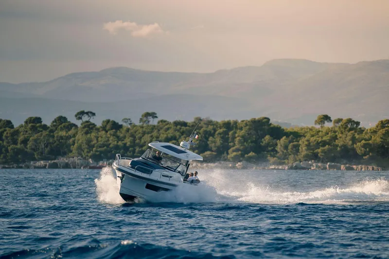 Slide: The Image of Nimbus Tender 11 boat cruising on open water, scenic mountain backdrop, 2025 model. - 22