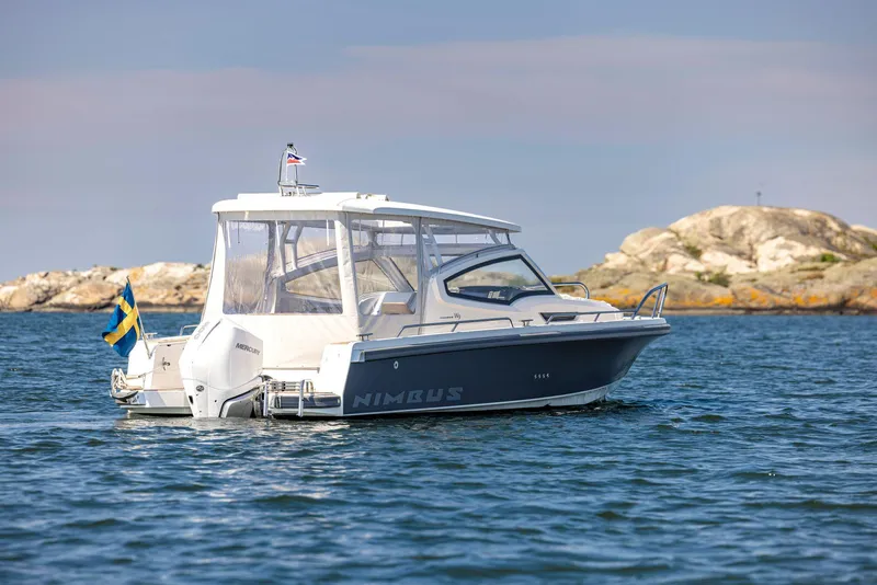 Slide: The Image of Nimbus Weekender 9 boat, 2025 model, cruising near rocky shoreline. - 14
