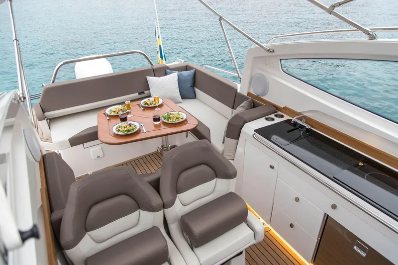 Slide: The Image of Luxurious 2025 Nimbus Weekender 9 boat interior with dining setup and kitchenette. - 19