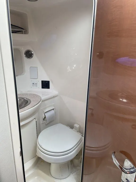 Slide: The Image of 2007 Chaparral 250 Signature boat bathroom with toilet and sink. - 5
