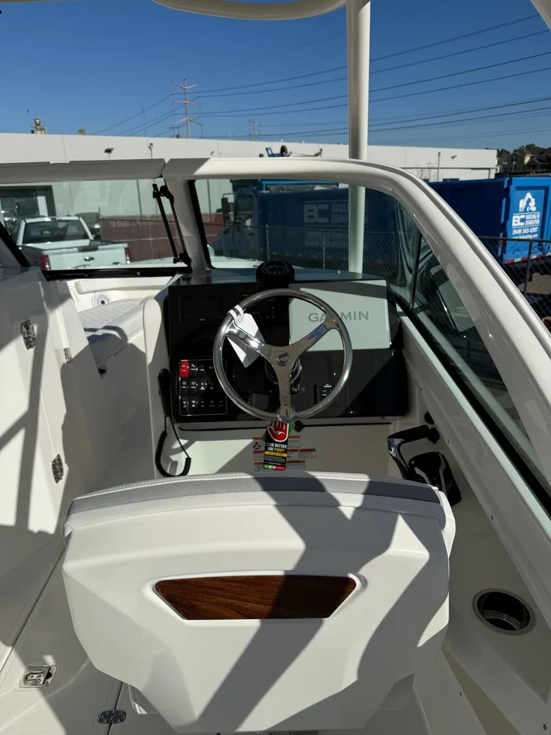 Slide: The Image of 2025 Pursuit DC 246 Dual Console boat interior with steering wheel and dashboard. - 9