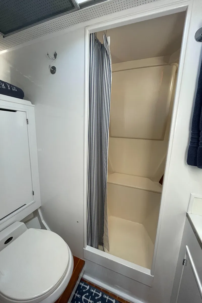 Slide: The Image of 1966 Huckins Sportsman bathroom with shower and toilet, featuring nautical decor. - 31