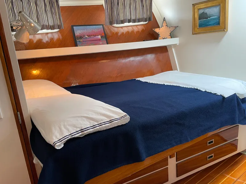 Slide: The Image of Cozy 1966 Huckins Sportsman cabin with bed, nautical decor, and wooden accents. - 43