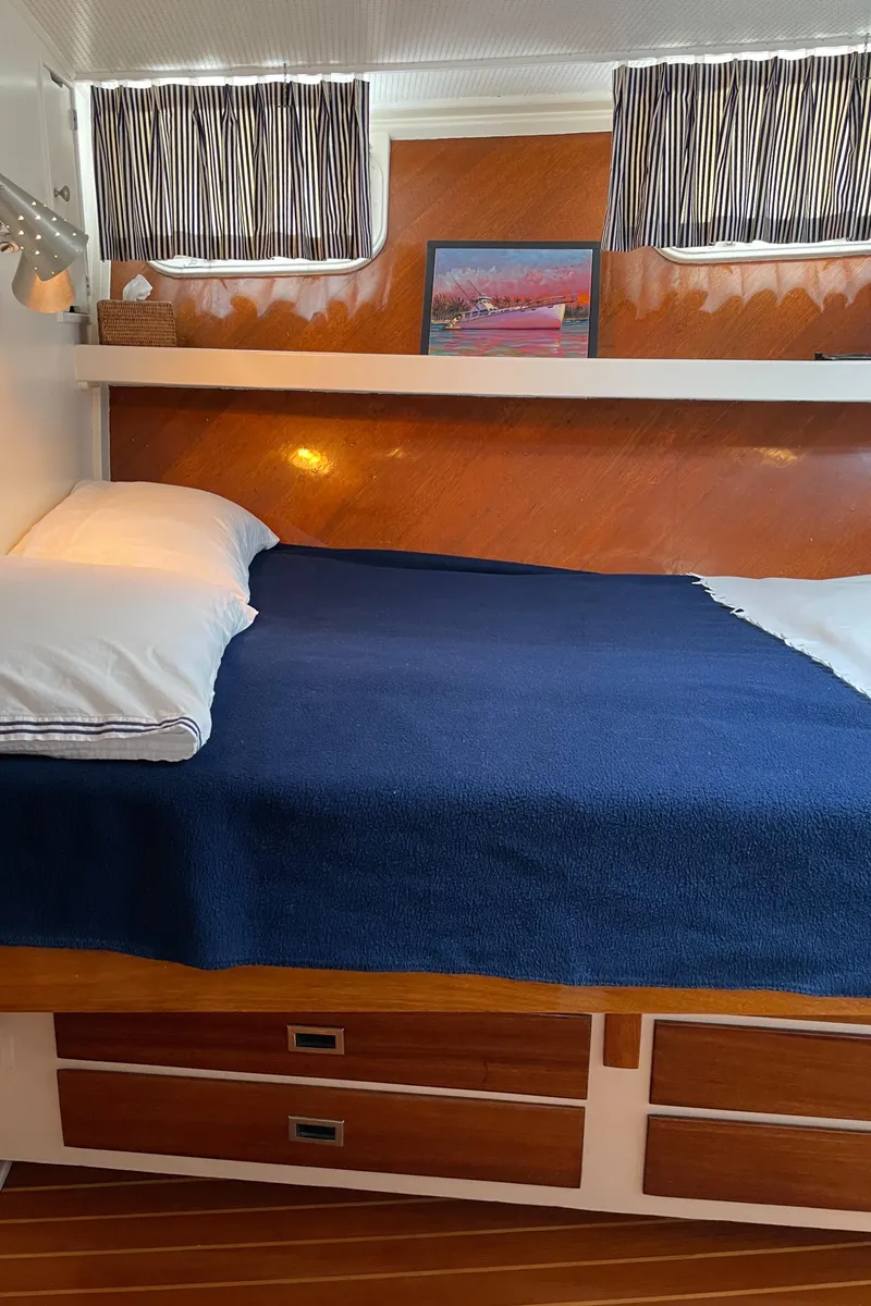 Slide: The Image of Cozy cabin interior of 1966 Huckins Sportsman with wood accents and blue bedding. - 45
