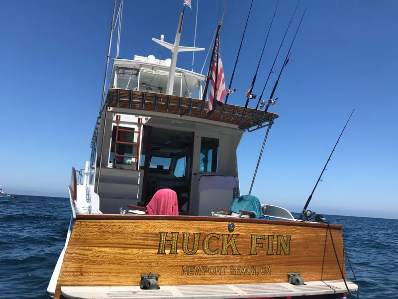 Slide: The Image of 1966 Huckins Sportsman boat "Huck Fin" on ocean, Newport Beach, fishing rods visible. - 7
