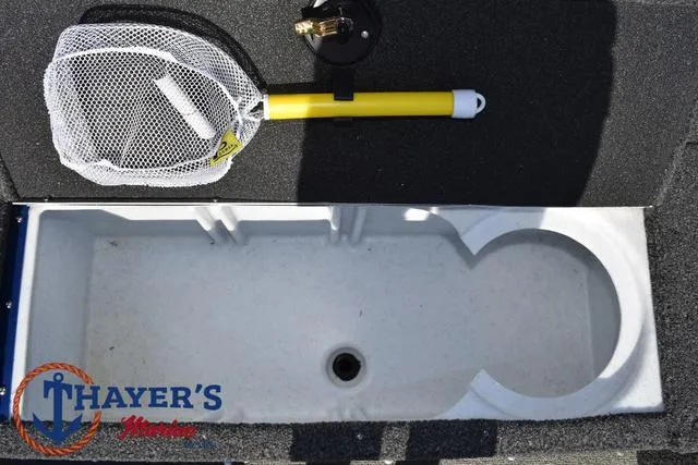 Slide: The Image of 2024 Lund 1650 Angler Tiller boat storage compartment with fishing net and rod holder. - 14