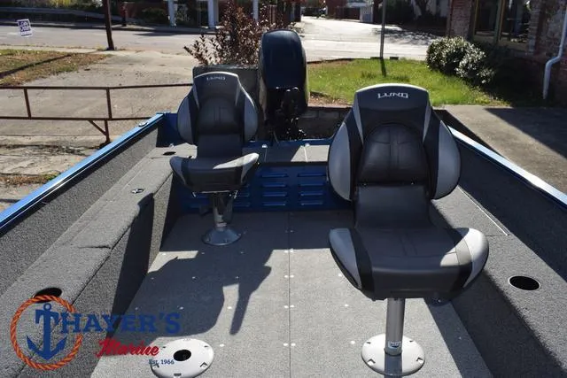 Slide: The Image of 2024 Lund 1650 Angler Tiller boat interior with two seats, outdoor setting. - 15