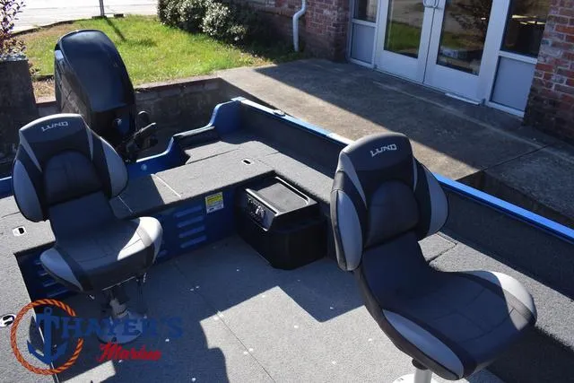 Slide: The Image of 2024 Lund 1650 Angler Tiller boat interior with seating and motor, outdoor setting. - 16