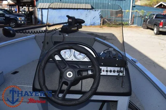 Slide: The Image of 2024 Lund 1600 Fury SS boat dashboard with steering wheel and controls. - 16