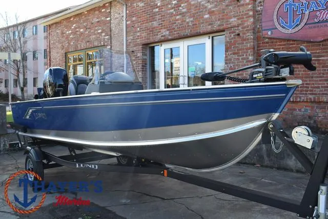 Slide: The Image of 2024 Lund 1600 Fury SS boat on trailer, blue exterior, parked outside brick building. - 27