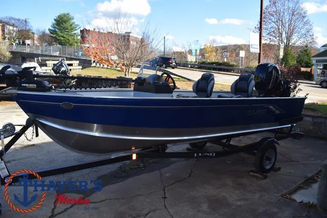 Slide: The Image of 2024 Lund 1600 Fury SS boat on trailer, blue exterior, parked outdoors. - 8