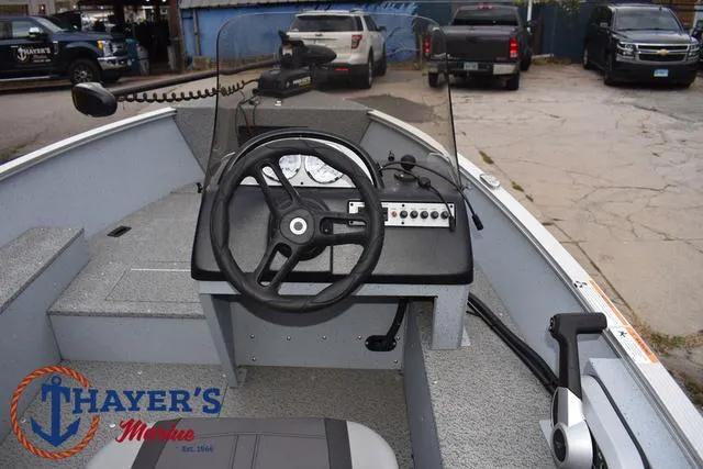 Slide: The Image of 2024 Lund 1600 Fury SS boat interior with steering wheel and dashboard controls. - 16