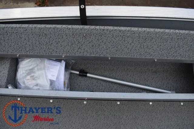 Slide: The Image of 2024 Lund 1600 Fury SS boat storage compartment with paddle and documents. - 18