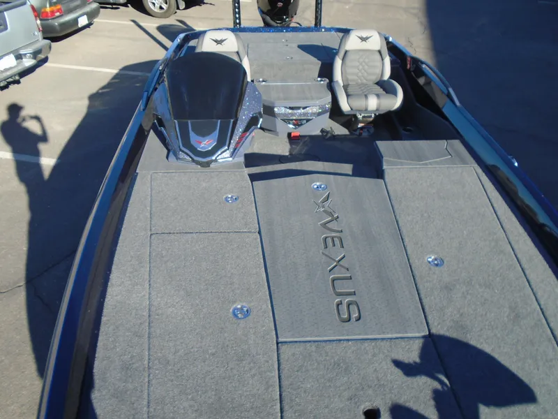 Slide: The Image of 2025 Vexus VX21 boat interior with seating and console, parked outdoors. - 16