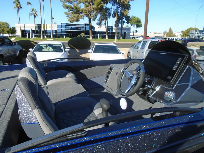 Slide: The Image of 2025 Vexus VX21 boat interior with steering wheel and dashboard, parked outdoors. - 9