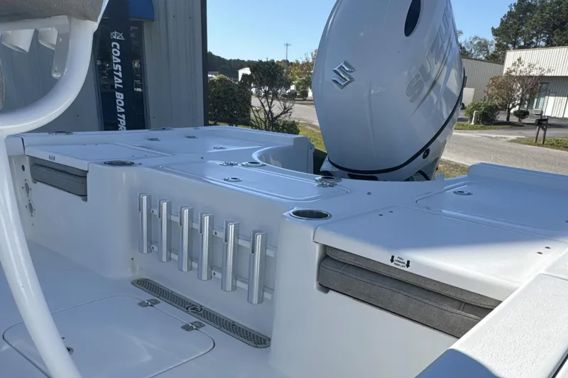 Slide: The Image of 2023 Sea Pro 228 Bay boat with Suzuki outboard motor, featuring rod holders and storage compartments. - 13