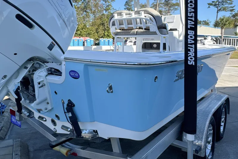 Slide: The Image of 2023 Sea Pro 228 Bay boat on trailer, light blue hull, outdoor display. - 22