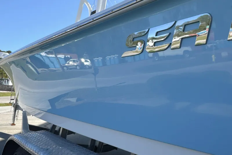 Slide: The Image of 2023 Sea Pro 228 Bay boat, blue hull with chrome logo, on trailer. - 5